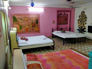 Duas camas num quarto com paredes cor-de-rosa em Golden Dreams Guest House em Jodhpur