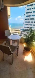 una mesa y sillas en un balcón con vistas al océano en Cabrero Beach 1111, en Cartagena de Indias