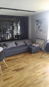 uma sala de estar com um sofá azul e piso em madeira em Słoneczny em Kielce