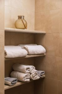 a bathroom with shelves with towels on them at Villa Emmanouela in Pitsidia