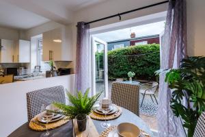 a kitchen and dining room with a table and a window at Welcoming 3 bed home, 10 mins from Chester races and zoo in Saughall