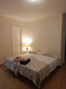 a bedroom with two beds with towels on the bed at APARTAMENTO PRÍNCIPE in Cáceres