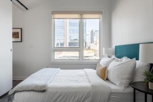 um quarto com uma grande cama branca e uma janela em Locale Lofts The Gulch - Nashville em Nashville