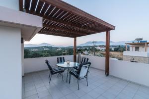 a patio with a table and chairs on a balcony at Villa Emanuela in Pitsidia