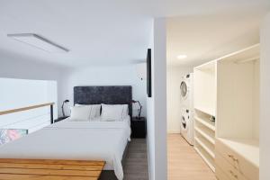 1 dormitorio con 1 cama blanca y cocina en Artist's Loft in the centre of Santa Cruz, en Santa Cruz de Tenerife