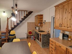 a kitchen with a table and a spiral staircase at Molnárkalács vendégház in Mátraszentimre