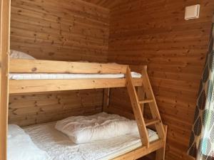 HusåにあるStuga Huså Åreのログキャビン内のベッドルーム1室(二段ベッド2組付)