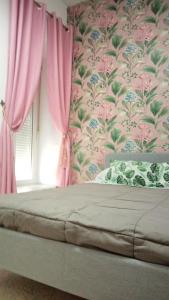 a bedroom with pink walls and a bed with pink curtains at Miriam Costa de la luz 2 in Jerez de la Frontera