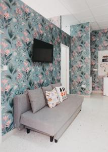 a living room with a couch and floral wallpaper at Miriam Costa de la luz 2 in Jerez de la Frontera