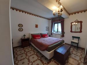ein Schlafzimmer mit einem Bett mit roten Kissen darauf in der Unterkunft Casa vacanze Daniela in Villetta Barrea