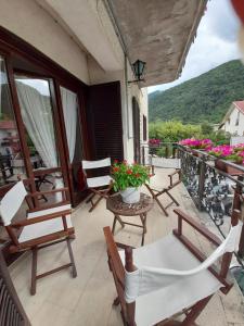 einen Balkon mit Stühlen und einem Tisch mit Blumen in der Unterkunft Casa vacanze Daniela in Villetta Barrea
