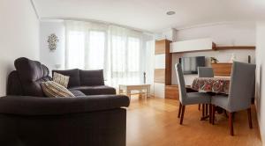 ein Wohnzimmer mit einem Sofa und einem Esstisch in der Unterkunft Apartamento céntrico cerca de las estáciones in Santander