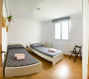 1 Schlafzimmer mit 2 Betten und einem Fenster in der Unterkunft Apartamento céntrico cerca de las estáciones in Santander