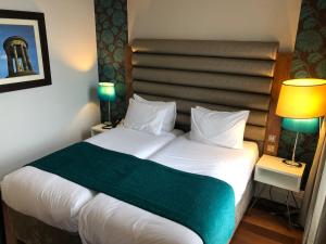 a bed with a white comforter and pillows at Hotel Indigo Edinburgh, an IHG Hotel in Edinburgh