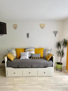 a white bed with colorful pillows on it in a room at Welcome to Hakuna matata ! in Chanteloup-en-Brie