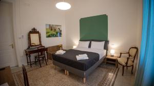 1 dormitorio con 1 cama con cabecero verde y espejo en Petrarca Suite, en Palermo