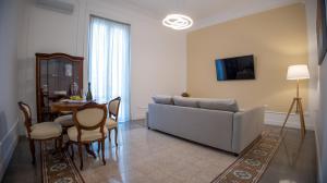 ein Wohnzimmer mit einem Sofa und einem Tisch in der Unterkunft Petrarca Suite in Palermo