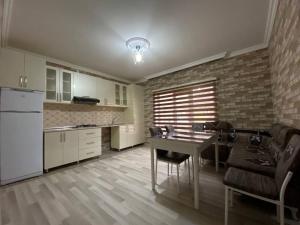 a kitchen with a table and chairs in a room at Qusar House in Qusar