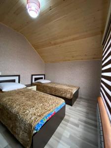クサールにあるQusar Houseの木製の天井の部屋にベッドが2つある