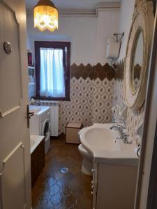ein Badezimmer mit einem Waschbecken, einem WC und einem Spiegel in der Unterkunft Casa vacanze Daniela in Villetta Barrea