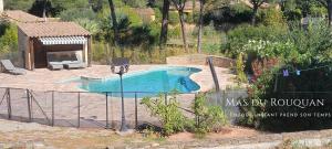 a swimming pool in a yard with a gazebo at Le Mas du Rouquan in Vidauban