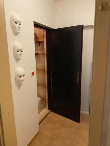 a bathroom with a door with masks on the wall at Adorable 1-bedroom guesthouse & private parking place in Velika Mlaka