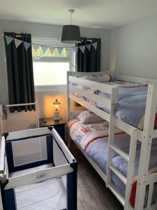 a bedroom with two bunk beds and a window at Hugo's hideaway Free WIFI in Hemsby