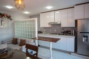 San Felipe Apartament في اروابان دل بروغرسو: مطبخ وغرفة معيشة مع طاولة وأريكة