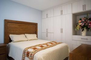 a bedroom with a bed and a vase of flowers at San Felipe Apartament in Uruapan del Progreso