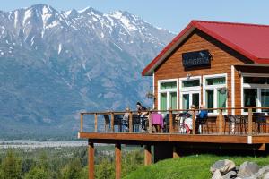 un grupo de personas sentadas en el balcón de una casa en Alaska Glacier Lodge en Palmer