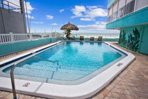 a swimming pool on top of a building with the beach at Arena De Madeira 502- Premier in St Pete Beach
