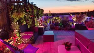 een patio met paarse verlichting, stoelen en planten bij Spa de la Lune - Private love room suite with terrace and view - Air Conditioned- Double jacuzzi - Sauna - King size bed - Free WIFI - Free parking - Free breakfast - Close to CDG airport and to the North of Paris in Clichy-sous-Bois