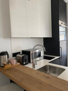 a kitchen with white cabinets and a sink at Enjoy B-52 Studio in Belgrade