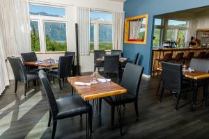 a dining room with tables and chairs and windows at Alaska Glacier Lodge in Palmer