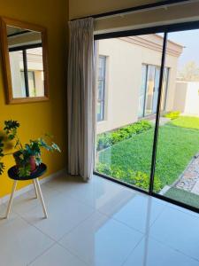 a living room with a large window and a plant at Styled bed and breakfast in Palatswe