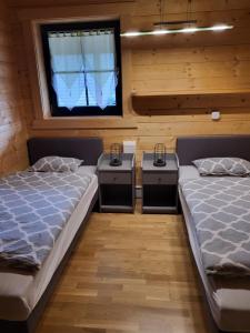 two twin beds in a room with a window at Blockhaus im Süden Deutschlands in Höchenschwand