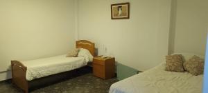 a room with two beds and a dresser in it at Alojamiento El Coco in Puerto Madryn