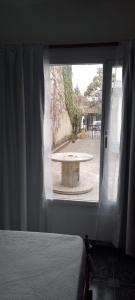 a bedroom with a view of a table through a window at Alojamiento El Coco in Puerto Madryn