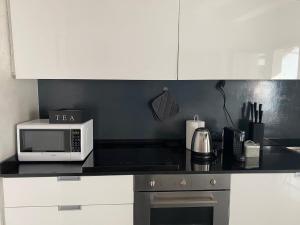 a kitchen with a counter top with a microwave at CasaMartaNavigli in Milan
