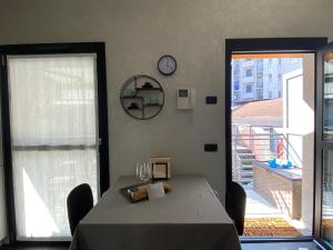 een eetkamer met een tafel en een klok aan de muur bij CasaMartaNavigli in Milaan
