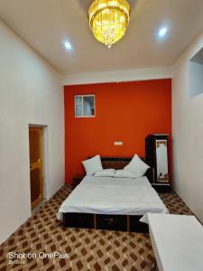 a bedroom with a large bed with an orange wall at PALL And SARKAR RESIDENCY in Srinagar