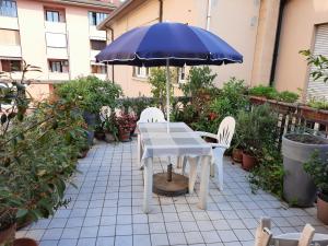 einen Tisch und zwei Stühle und einen Regenschirm auf einer Terrasse in der Unterkunft b&b del vicolo in Cesena