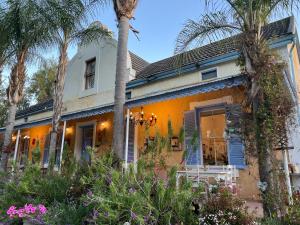 una casa arancione con palme e fiori di Yellow Aloe a Clanwilliam