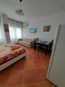 ein Schlafzimmer mit einem Bett, einem Tisch und einem Sofa in der Unterkunft Tomas Apartments Durres 1 in Durrës