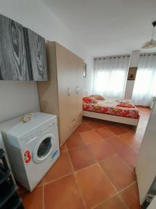 Zimmer mit einer Waschmaschine und einem Bett in der Unterkunft Tomas Apartments Durres 1 in Durrës