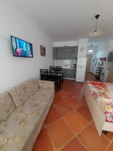 ein Wohnzimmer mit einem Sofa und einem Tisch in der Unterkunft Tomas Apartments Durres 1 in Durrës