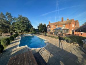 una piscina davanti a una casa di Warren Farm Farmhouse nr Oxford a Culham