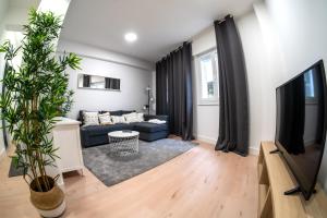 a living room with a blue couch and a tv at DADO HOST in Vigo