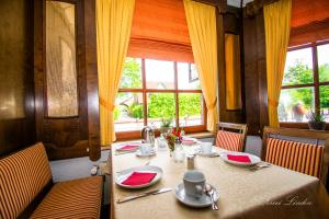 une salle à manger avec une table avec des serviettes rouges et une table dans l'établissement Hotel Zwei Linden - links der Elbe - Niedersachsen, à Balje