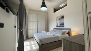 um quarto com uma cama com lençóis brancos e uma luz em Pompei Next em Scafati